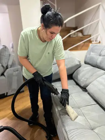 Aluna higienizando sofá